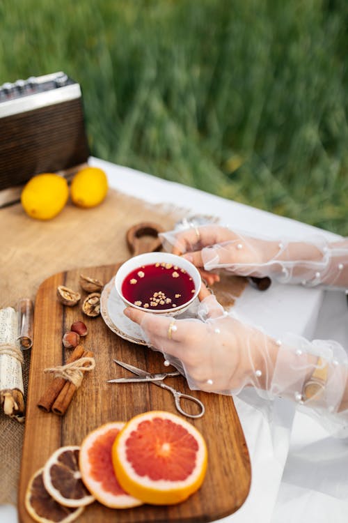 A woman is holding a cup of tea on a wooden tray