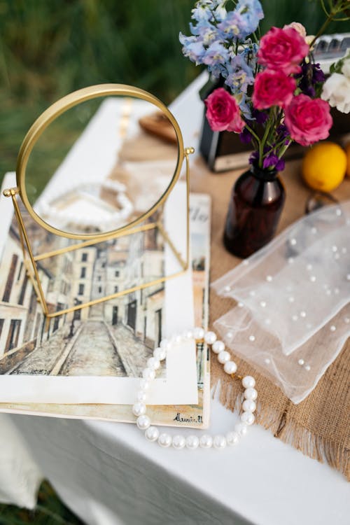 A table with a mirror, flowers and jewelry