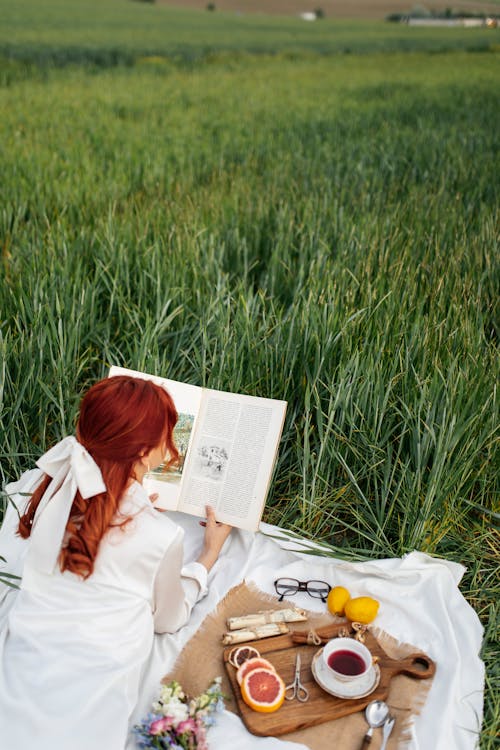 A woman reading a book in a field