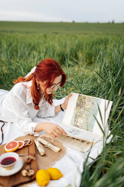 A woman reading a book in the grass