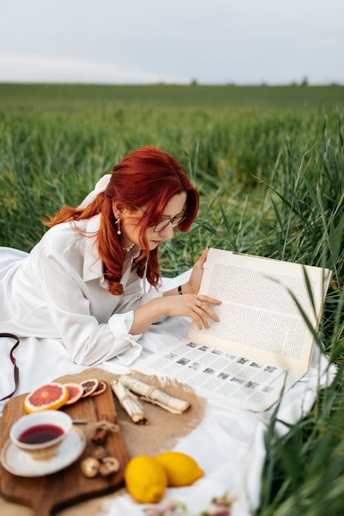 A woman reading a book in a field