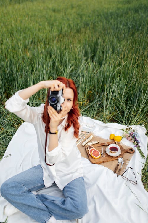 A woman taking a photo of herself in a field