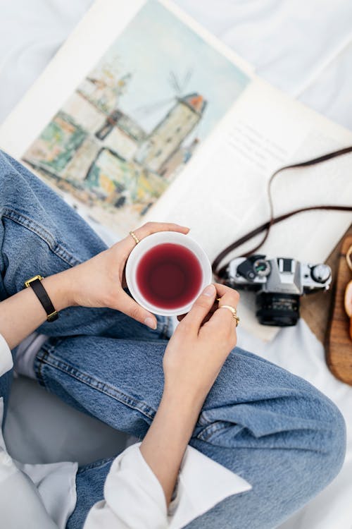 A woman holding a cup of coffee and a book