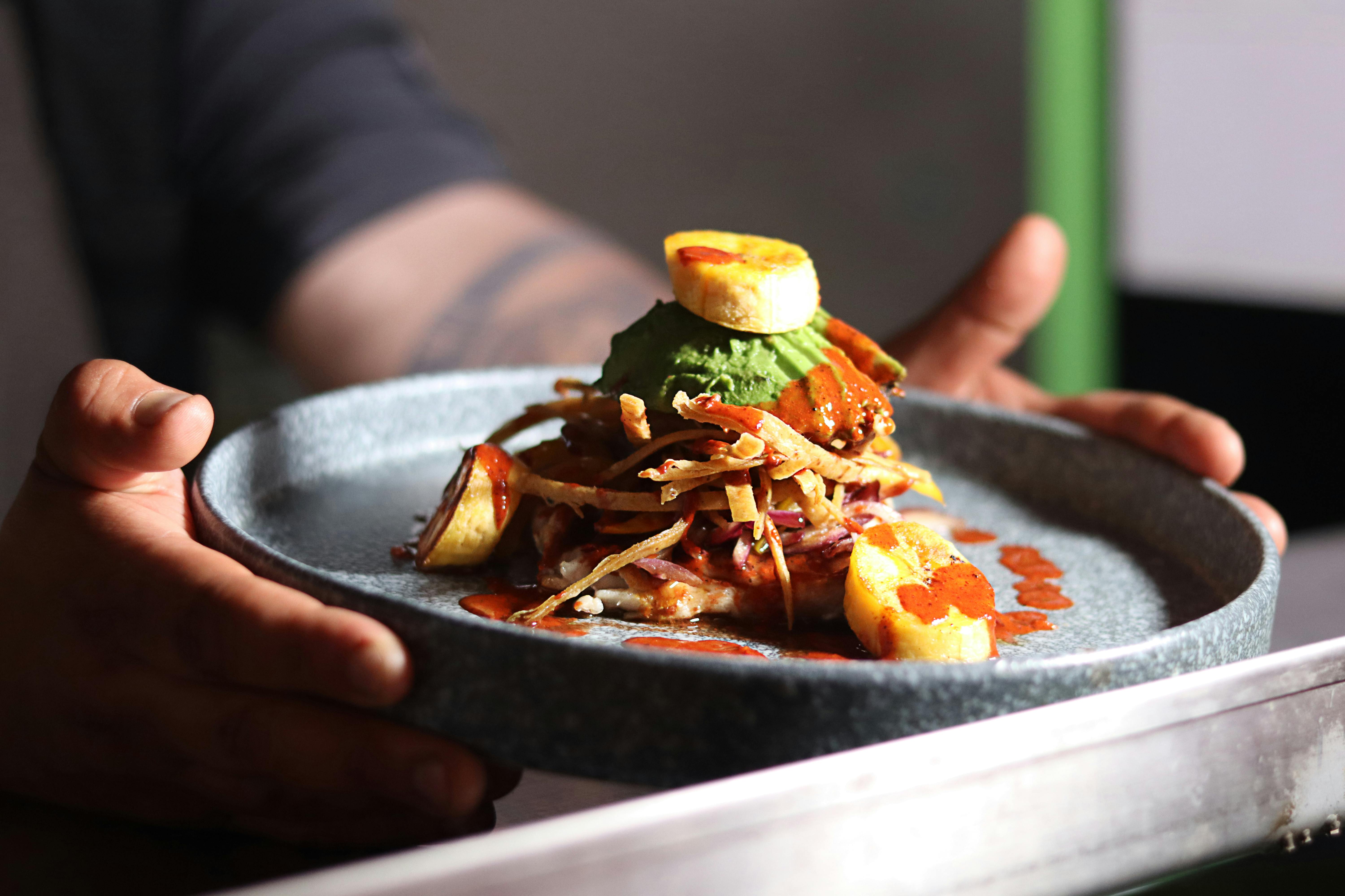 A delicious gourmet meal featuring plantains and sauce, elegantly plated and ready to serve.