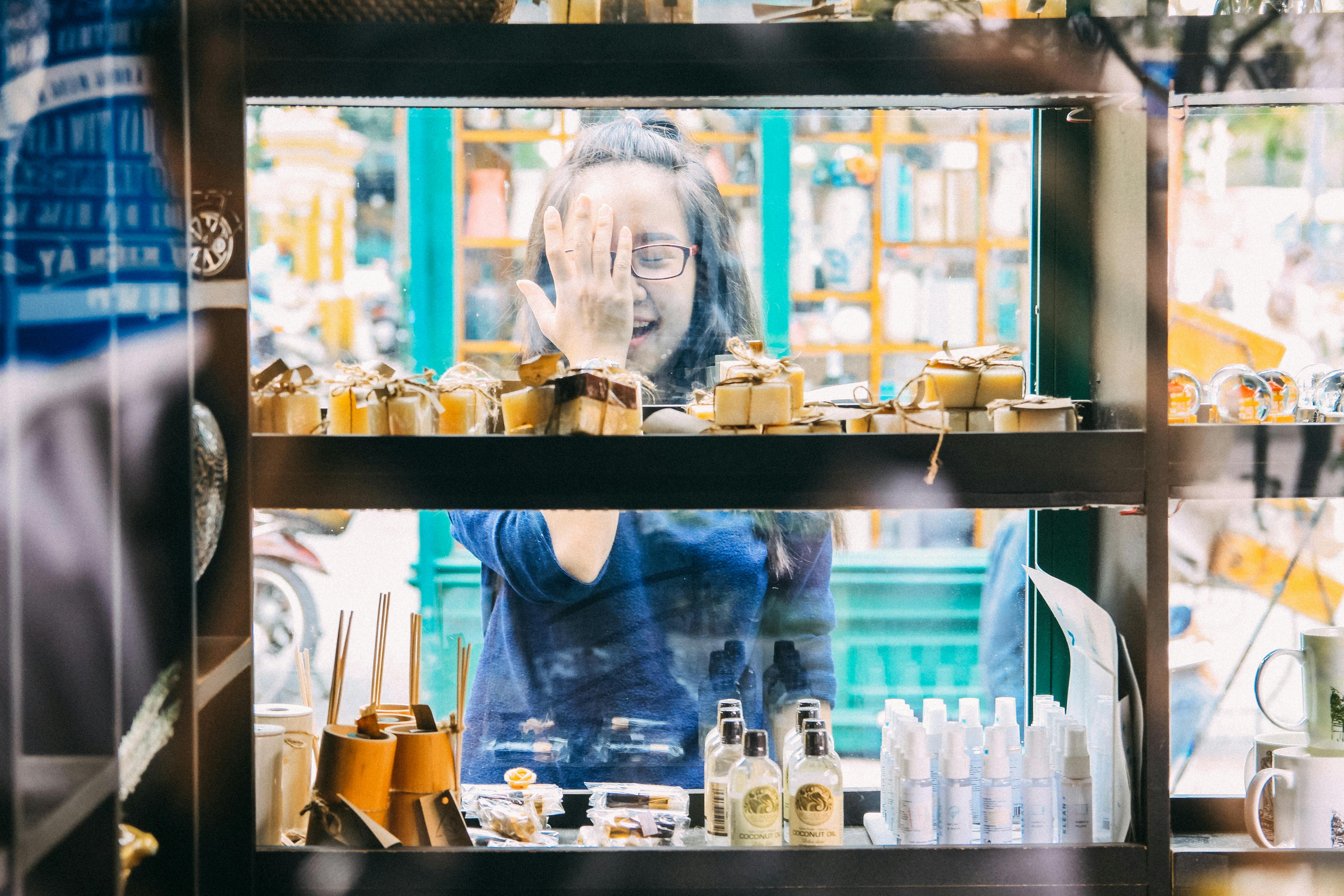 Woman Standing Beside Clear Glass Display Counter
