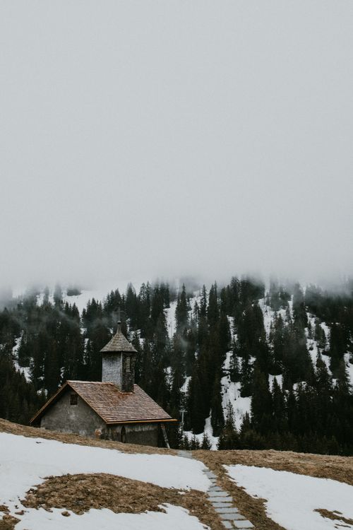 Free A quaint chapel amidst foggy snow-covered mountains in Le Grand-Bornand, France. Stock Photo