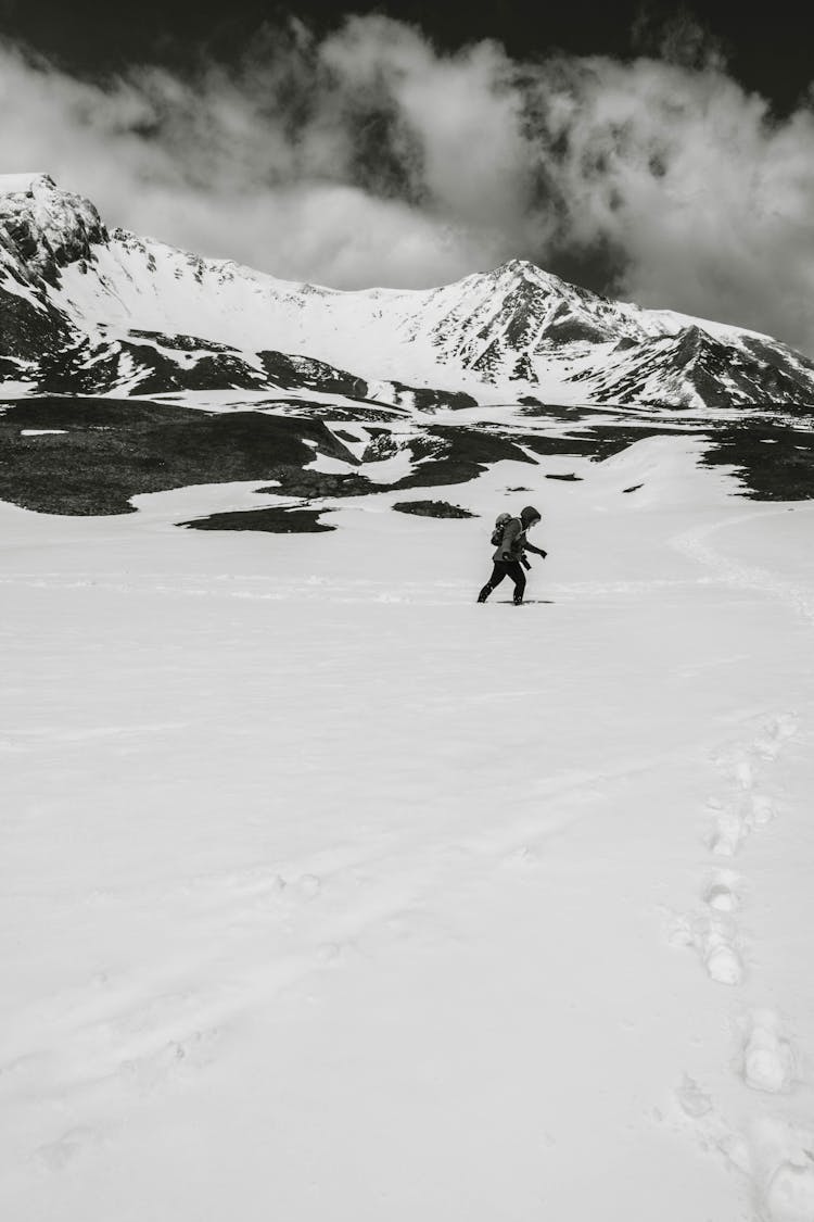 Man Standing On Snow Covered Mountain