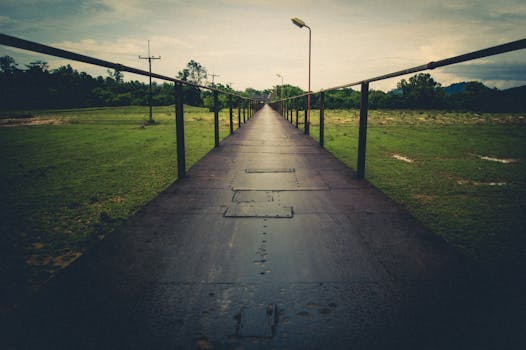 在泰国乡村的郁郁葱葱绿地中，一座金属桥非常适合旅行探索