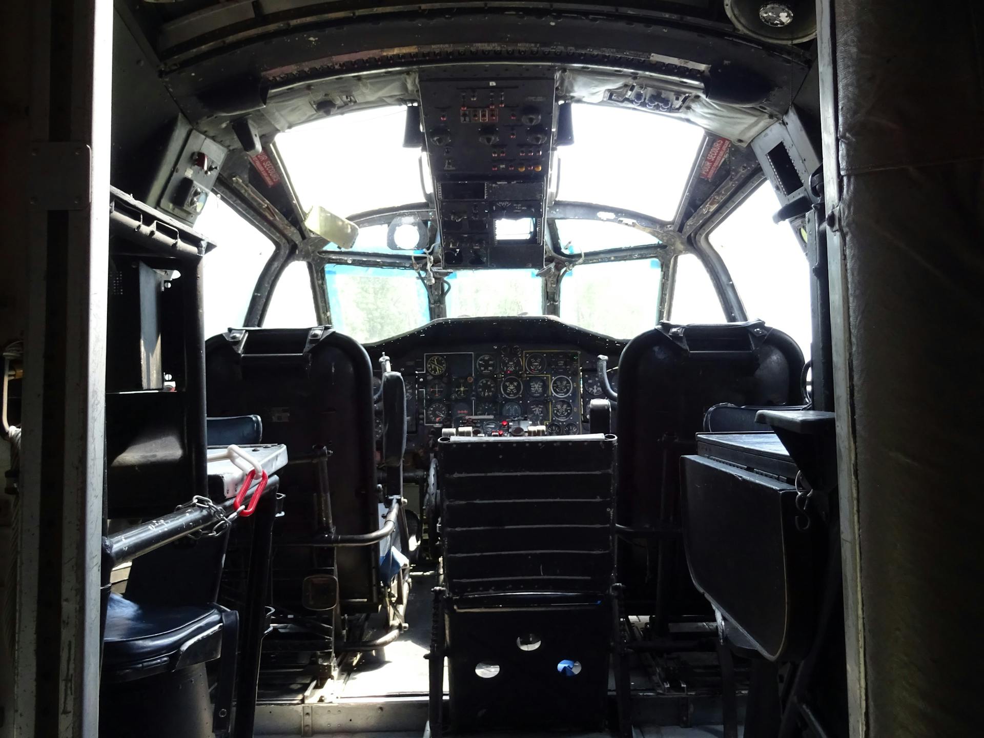 An interior view of an airplane cockpit showcasing seats and control panels.