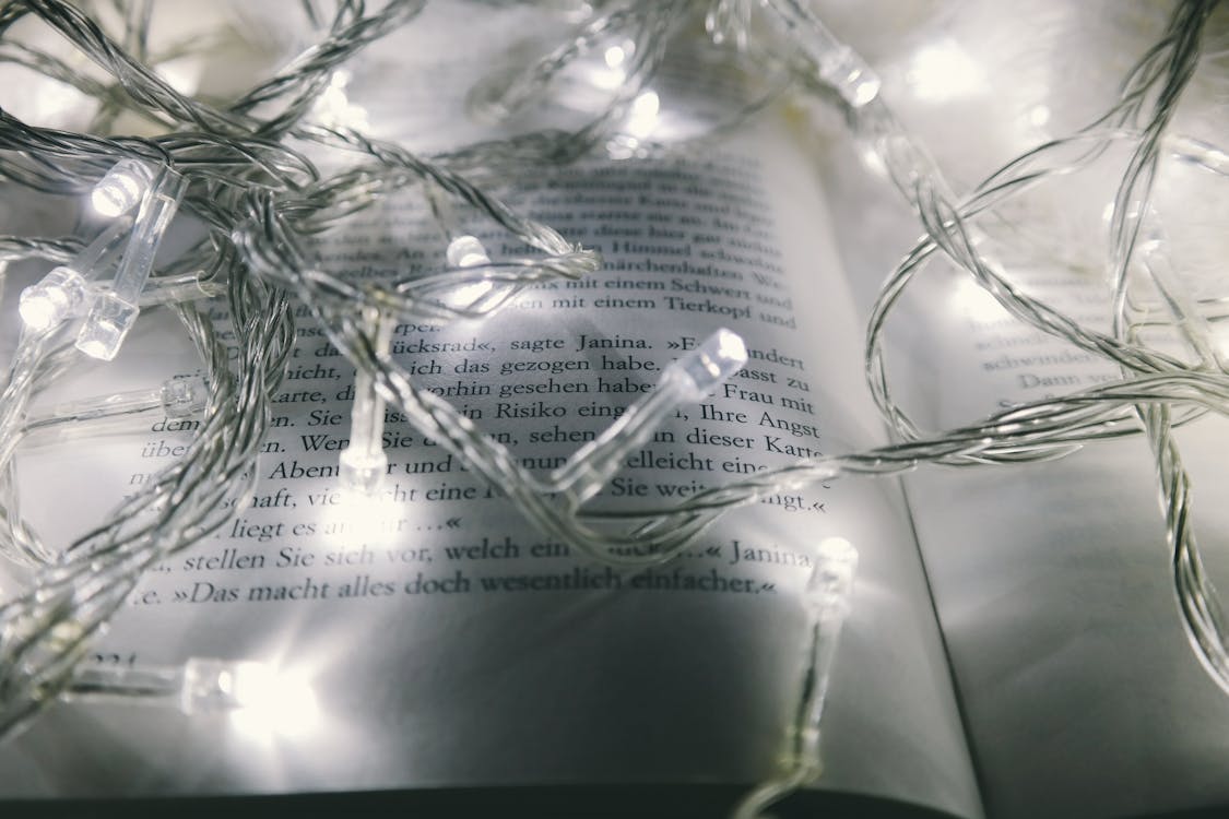 White String Lights Turned-on on Opened Book
