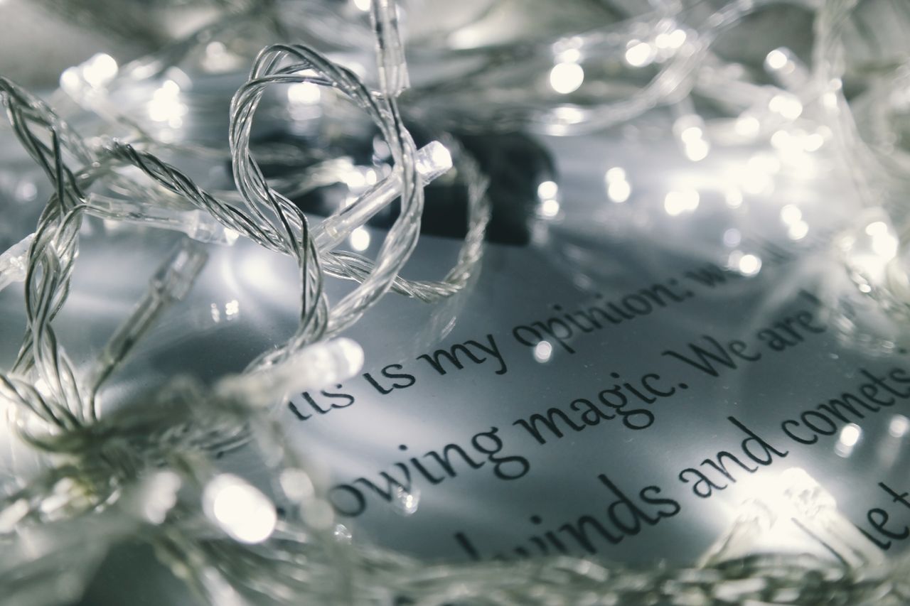 close up of glowing christmas string lights draped over a page with in