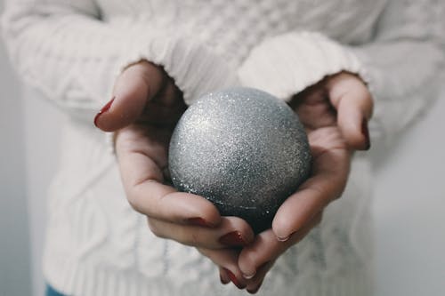 Selective Focus Photography Person Holding Gray Metal Ball