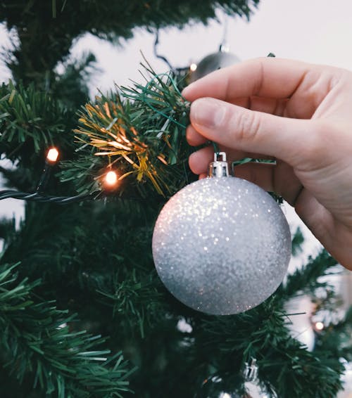 Person Holding Silver Glittered Bauble