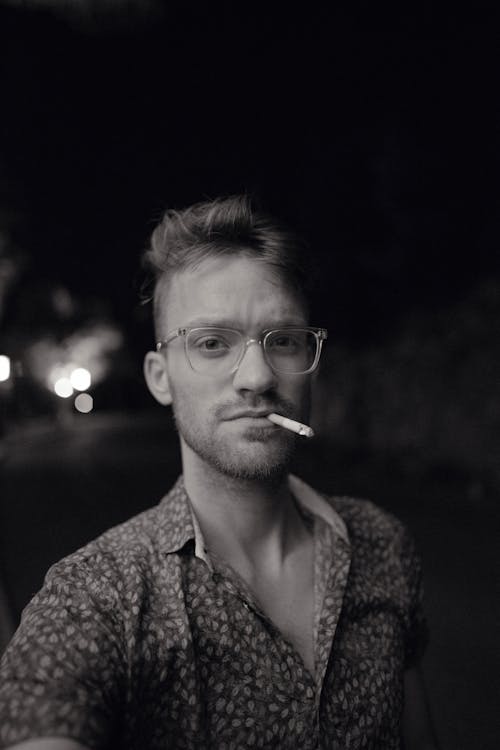 Monochrome Photo of Man Smoking Cigarette