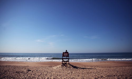 Free Photo of Person Sitting on Lifeguard Tower Stock Photo
