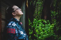 一个女人穿着星球大战夹克，站在户外的绿色植物中