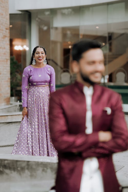 A man and woman in purple outfits standing outside