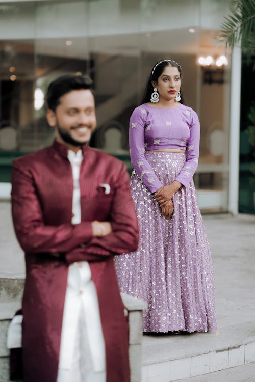 A man and woman in purple outfits standing next to each other