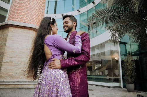 A couple in purple attire hugging each other