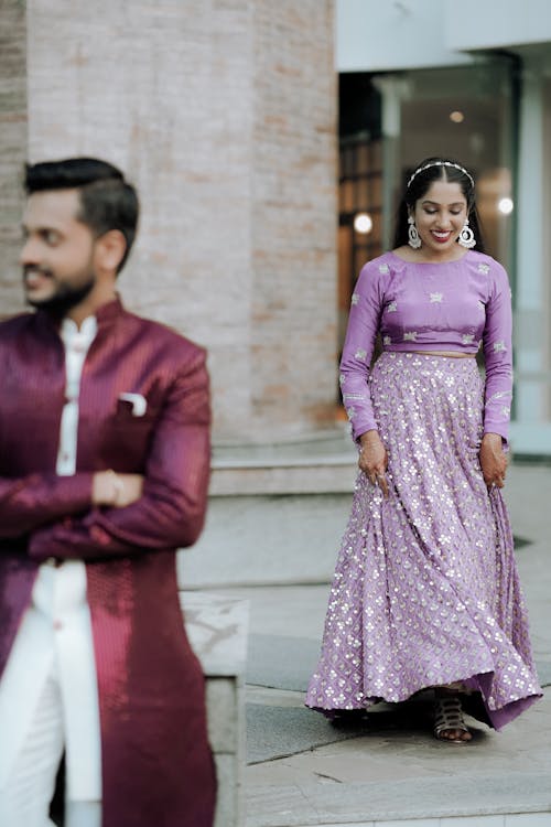 A couple in purple outfits standing outside