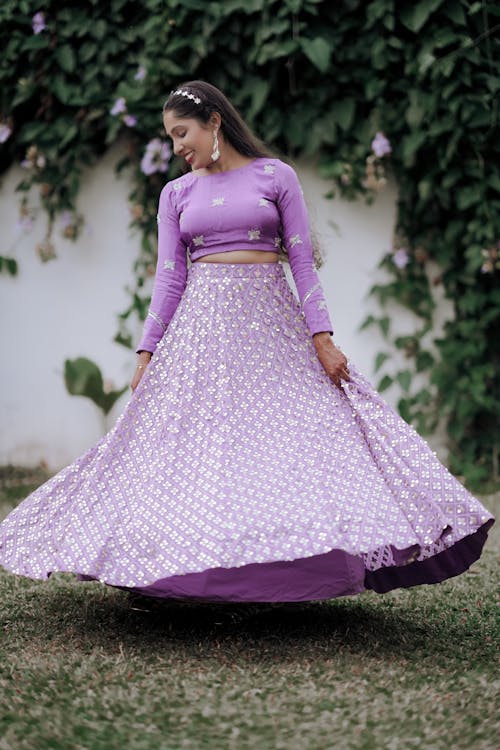 A woman in a purple lehenga with a white top