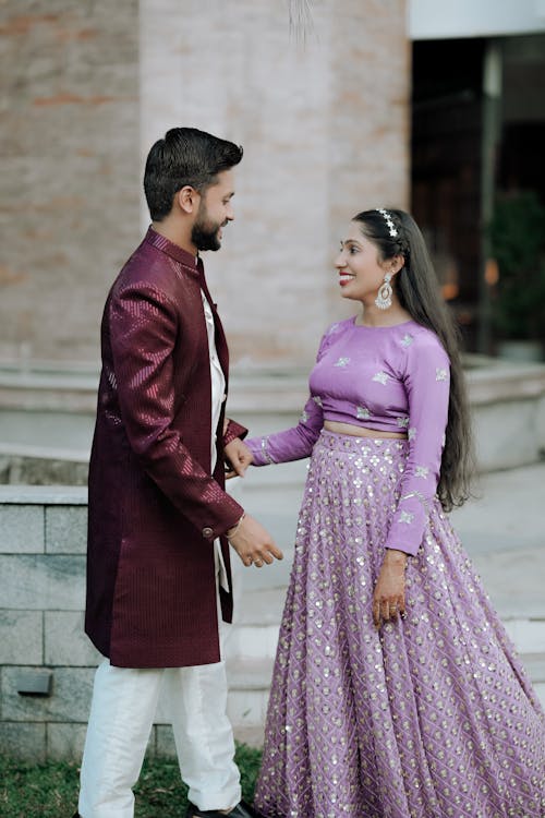 A man and woman in purple outfits standing next to each other