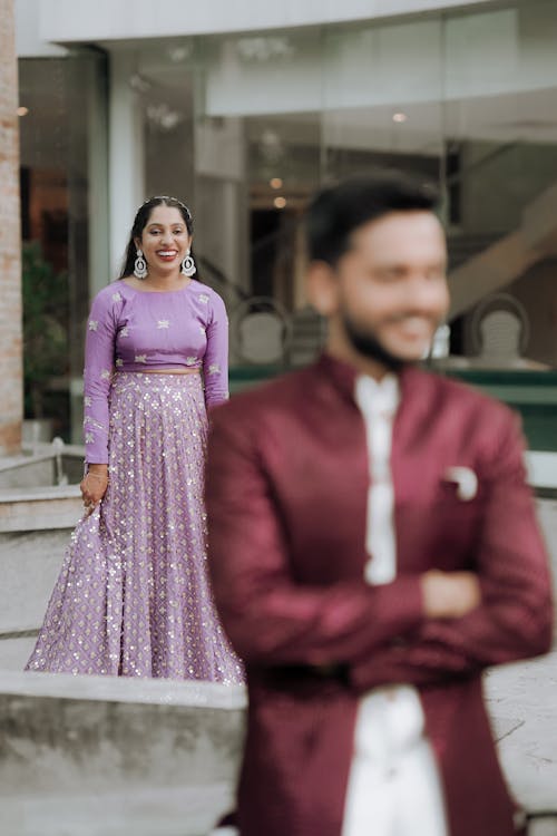 A man and woman in purple and gold outfits