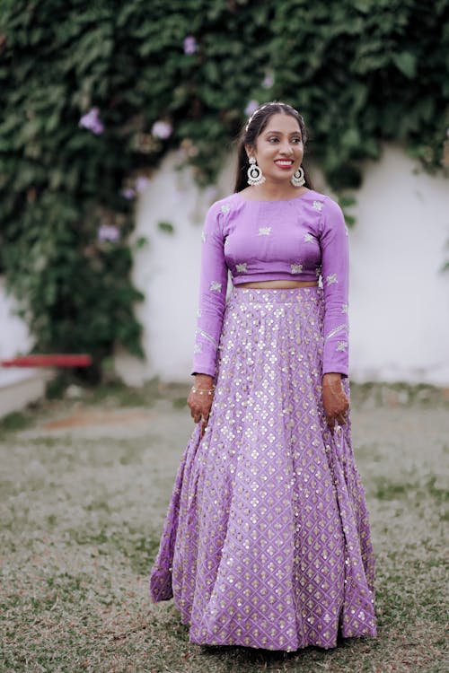 A beautiful woman in purple lehenga and crop top