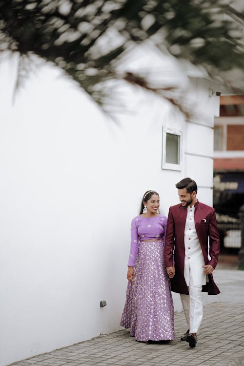 A couple in traditional indian attire walking down the street