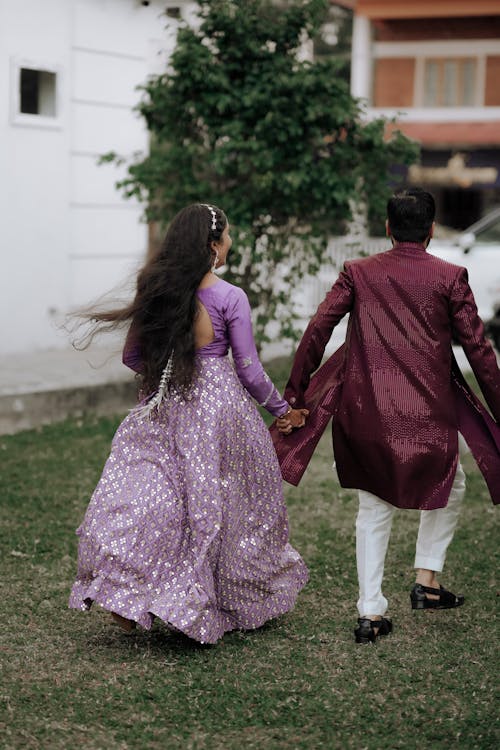 A man and woman in purple dress walking together