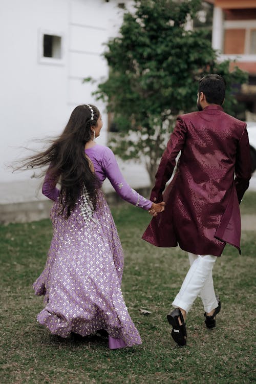 A man and woman in purple dress walking together
