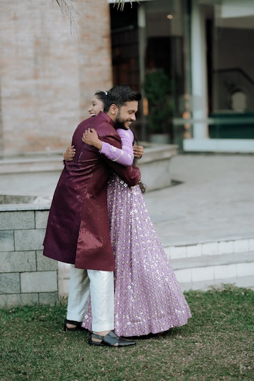 A man hugging a woman in a purple dress