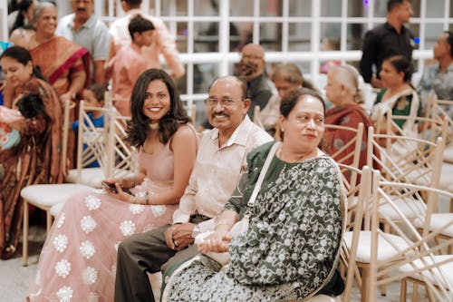 An indian wedding with people sitting in chairs