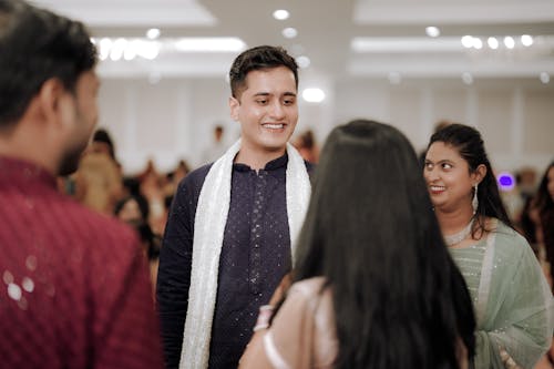 A man in a white shirt and blue tie is talking to a woman