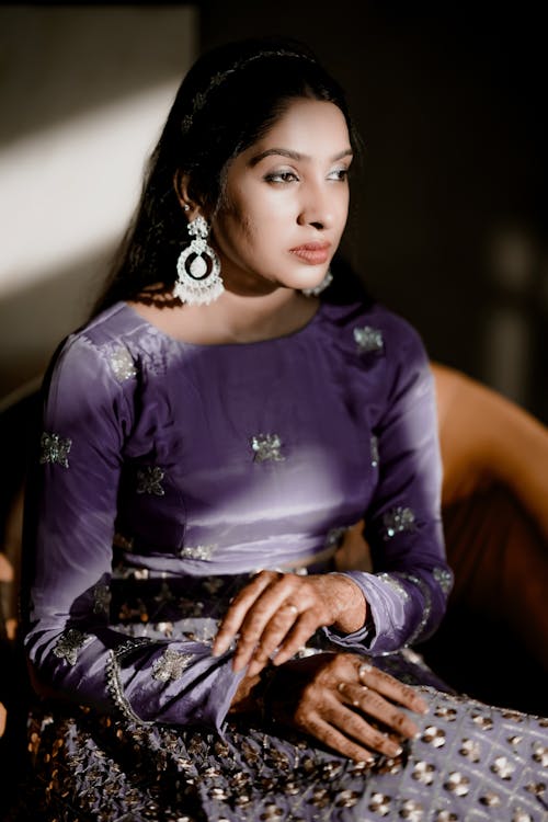 A woman in purple dress sitting on a chair
