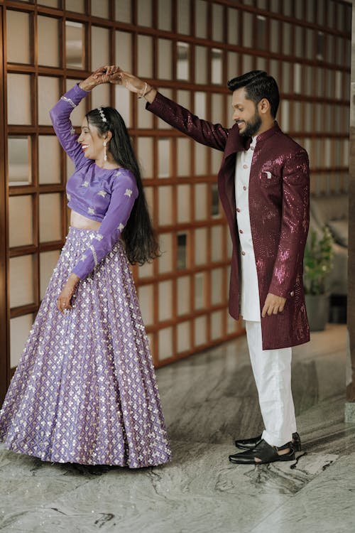 A man and woman in purple and white outfits