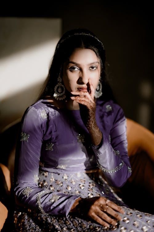 A beautiful woman in a purple dress sitting on a chair