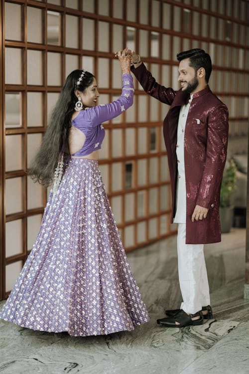 A man and woman in purple and white outfits dancing