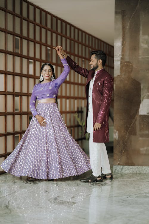 A couple in purple lehenga pose for a photo