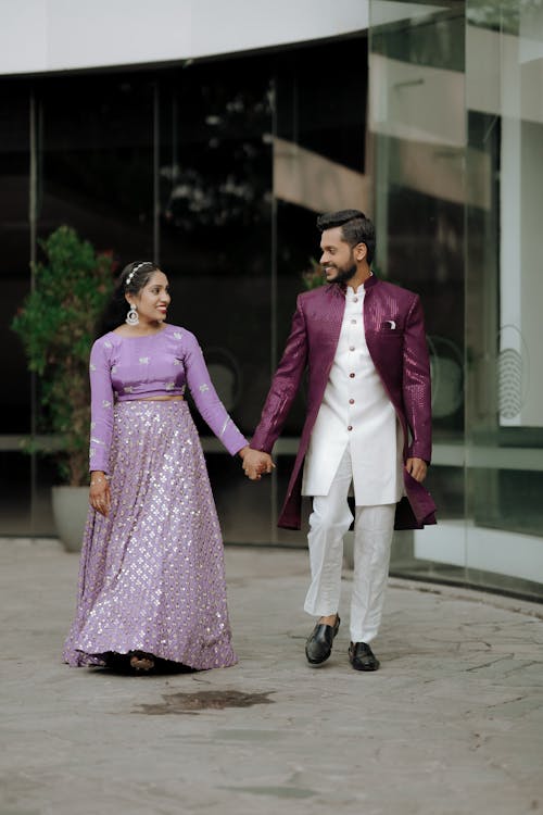A man and woman in purple attire walking together