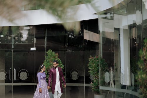 A couple walking in front of a glass building