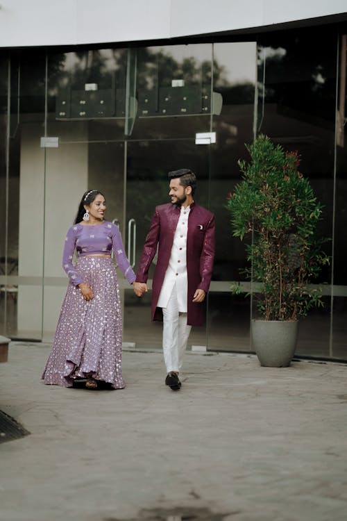 A man and woman in traditional attire walking down the street