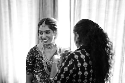 A woman in traditional indian clothing is getting ready for her wedding