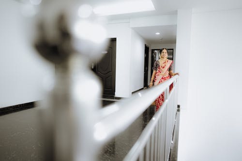 A woman in a red sari standing on a stairway