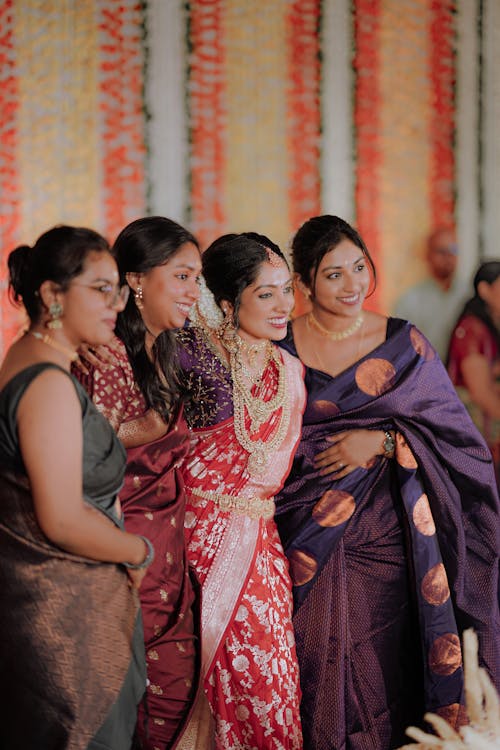 A group of women in sari's are standing together