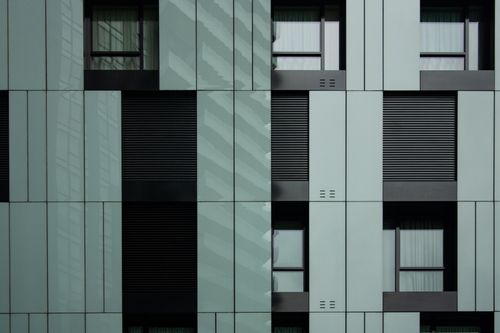 Free Detailed view of a modern building facade in Milan showcasing sleek design and glass elements. Stock Photo