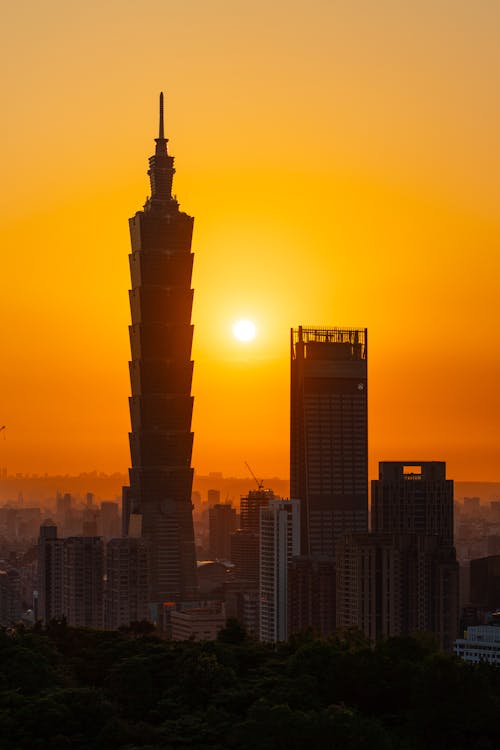 The sun sets over the city skyline with the taipei tower in the background