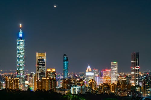 Taipei city skyline at night with moon in the sky