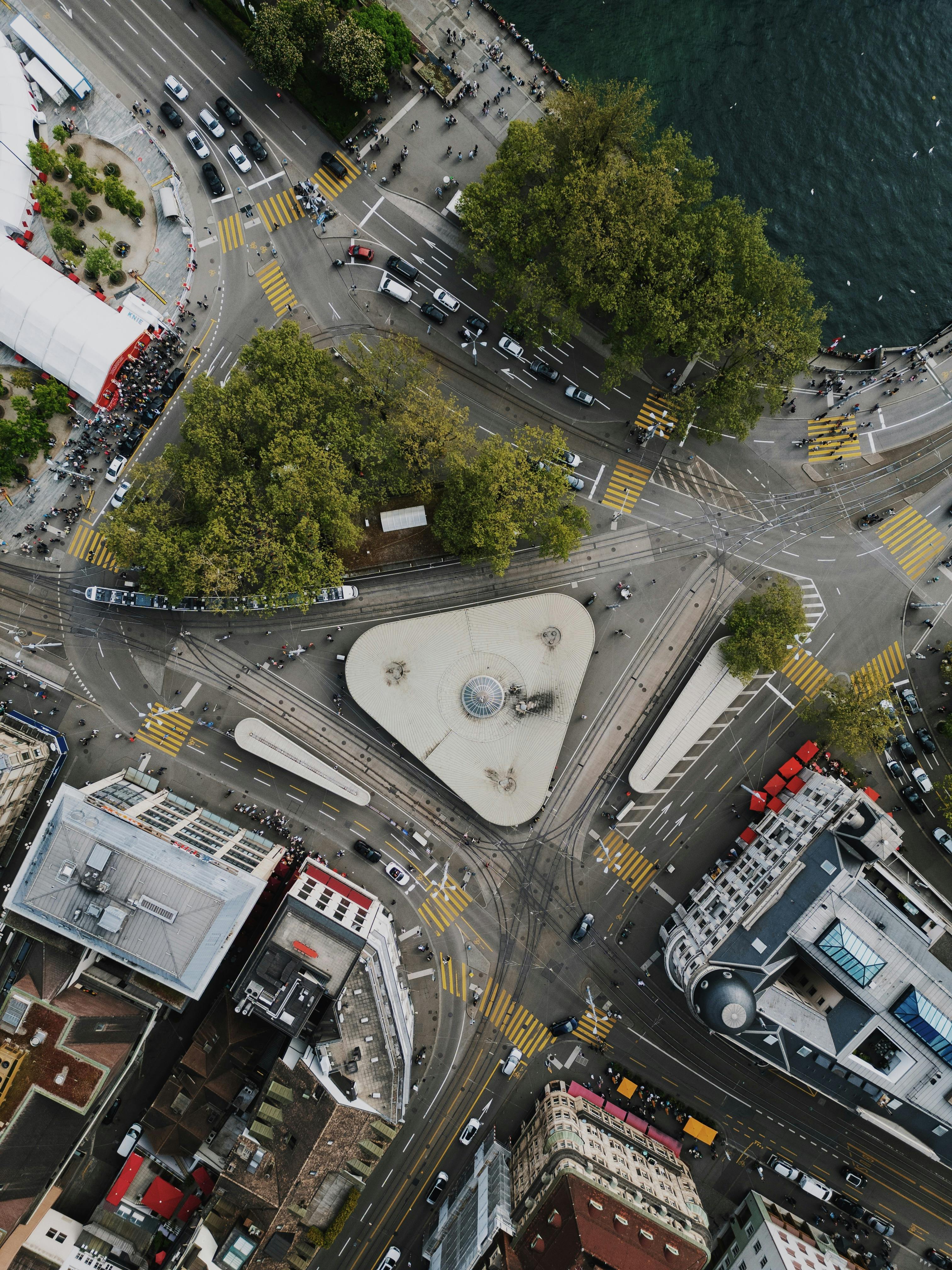 Aerial view of a bustling traffic circle in central Zurich, Switzerland, surrounded by trees and buildings.