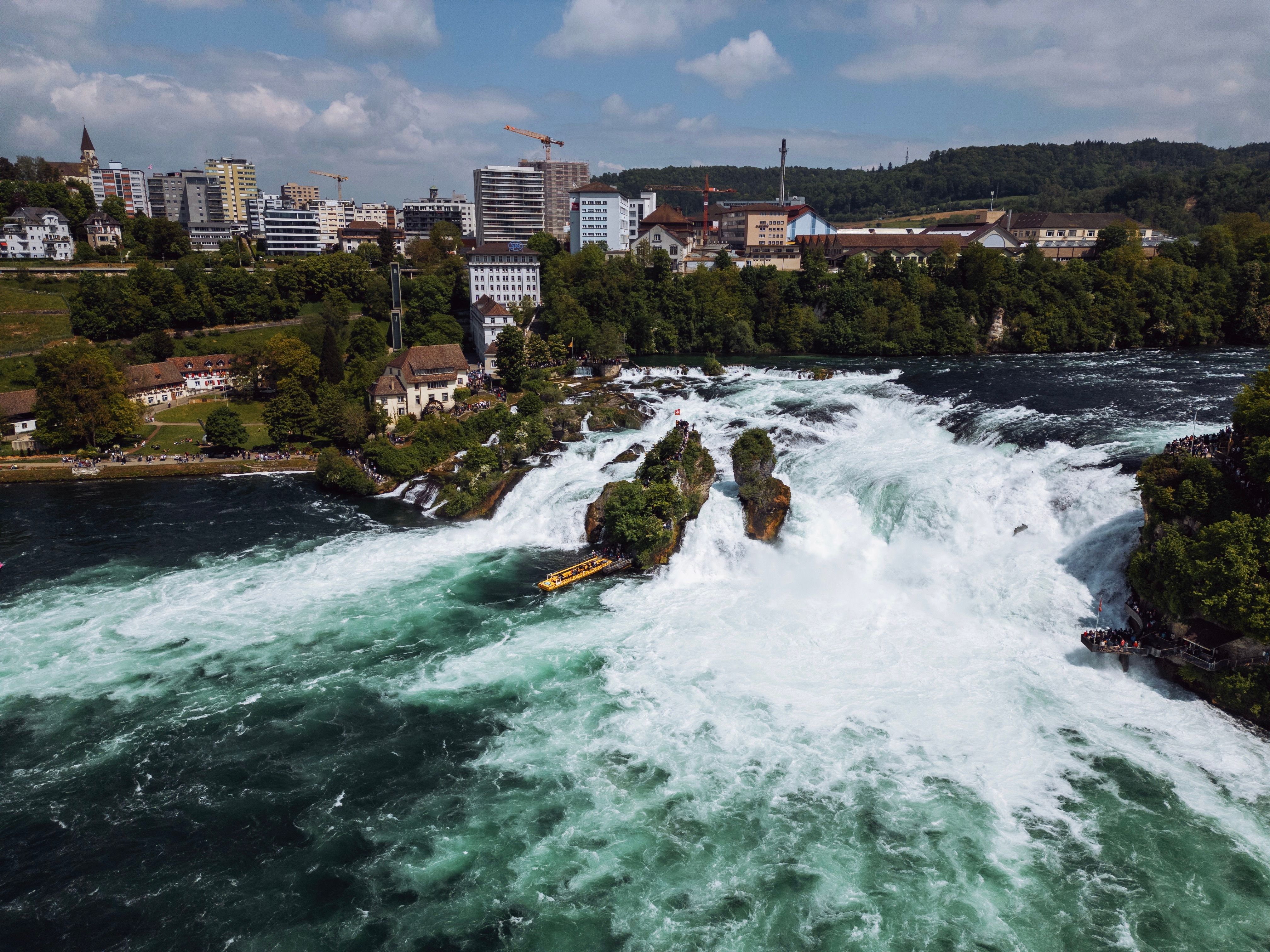 Best Private Helicopter Tour to Jura and Seeland - A Beautiful Sightseeing Flight Review Review 2026 - Breathtaking aerial view of Rhine Falls with surrounding townscape in Neuhausen, Switzerland.